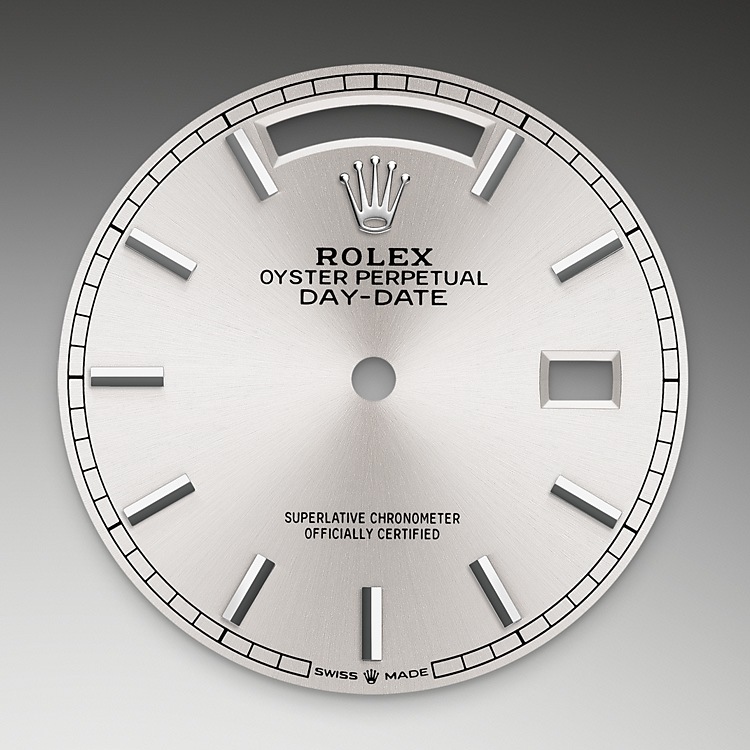 Day-Date M128239-0005 - La finitura <i>soleil</i> crea delicati riflessi di luce su molti quadranti della collezione Oyster Perpetual. Per ottenerla, si fa ricorso a sapienti tecniche di spazzolatura che producono lievi scanalature che si diramano dal centro del quadrante verso l’esterno. La luce si propaga uniformemente lungo ogni incisione, dando vita a un leggero, caratteristico bagliore che si sposta a seconda della posizione del polso. Una volta che la finitura <i>soleil</i> è stata completata, il colore del quadrante viene applicato usando la deposizione fisica da vapore o la galvanoplastica. Un sottile strato di vernice conferisce al quadrante il suo aspetto finale. | L'Angolo delle Ore